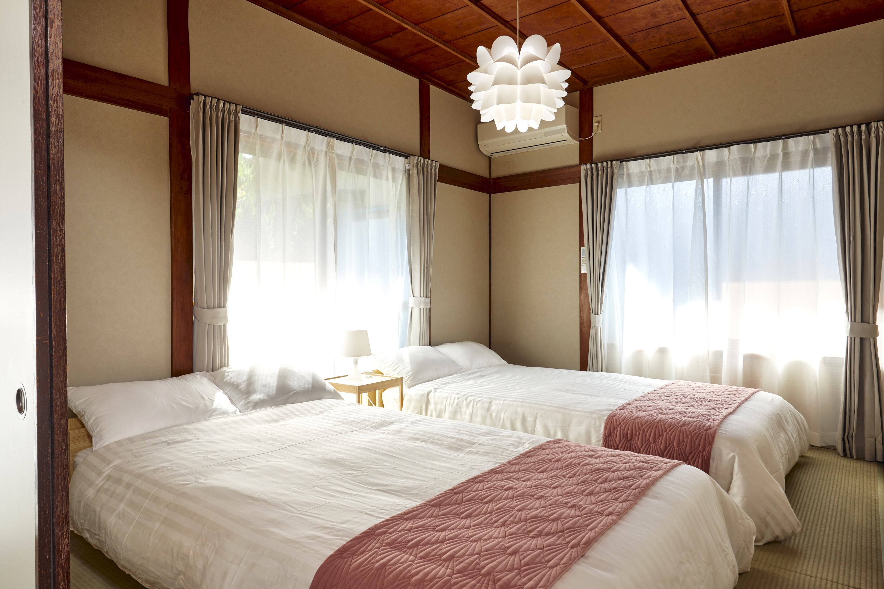 寝室3。温かみのある和室。花形ペンダントランプと白い寝具のツインベッド