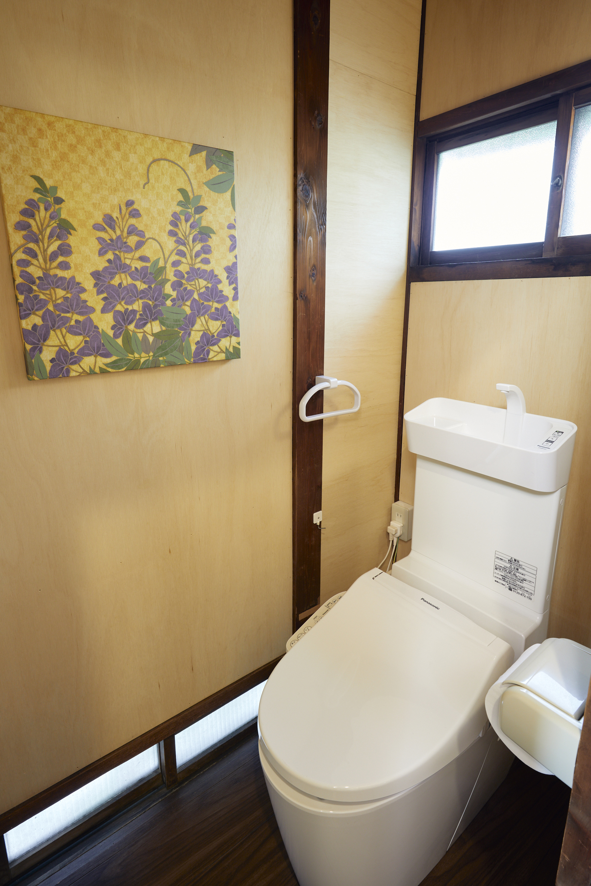 トイレ。藤の花を描いた鮮やかな絵画と清潔な洋式トイレ